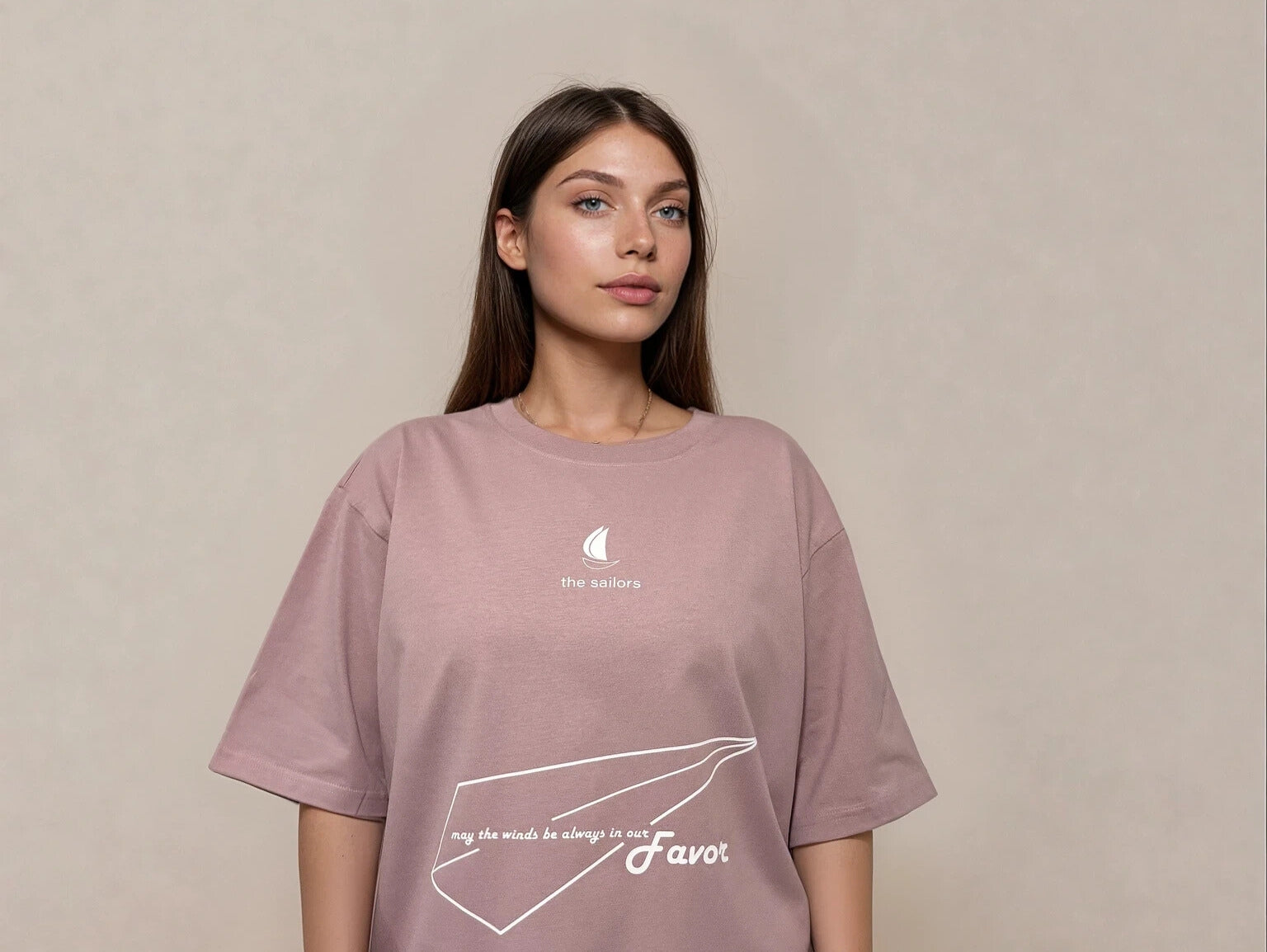 Woman wearing a pink t-shirt with white text and graphics on a beige background