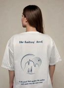 Person wearing a white t-shirt with 'The Sailors' Rock' design and text.